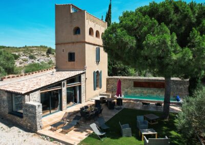 Vue aérienne par drone d’une maison avec tour, terrasse et piscine