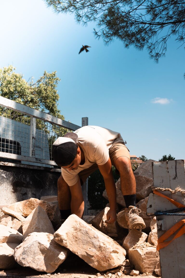 Artisan paysagiste déplaçant des pierres sur un chantier