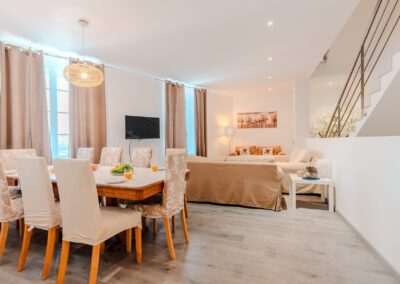 Pièce de vie avec grande table à manger et salon, maison de location