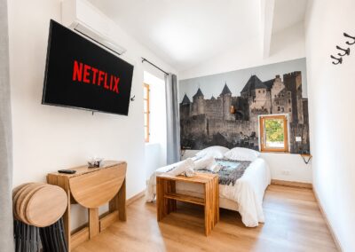 Studio meublé à Carcassonne photographié pour Airbnb, chambre avec fresque de la Cité
